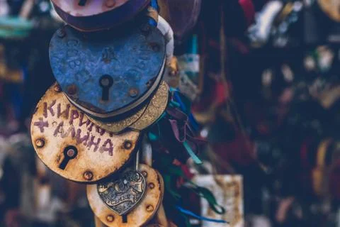Close up of a love lock on a railing on a locks bridge with other locks blurred Stock Photos