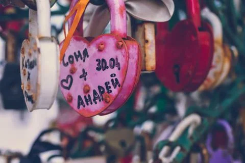 Close up of a love lock on a railing on a locks bridge with other locks blurred Stock Photos