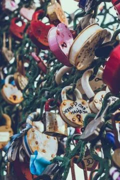 Close up of a love lock on a railing on a locks bridge with other locks blurred Stock Photos