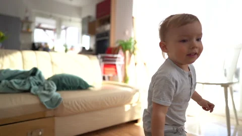 Close up of lovely blond boy three years old runs around the house and has fun Stock Footage 148666144
