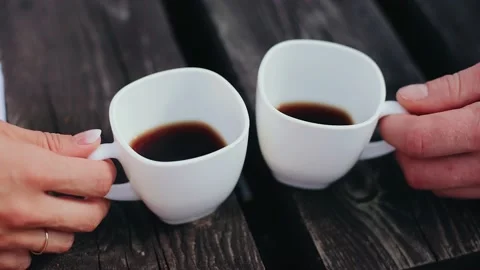 Close-up of lovers' hands with cups of coffee. Lovers are treated to drinks Stock Footage 226895813