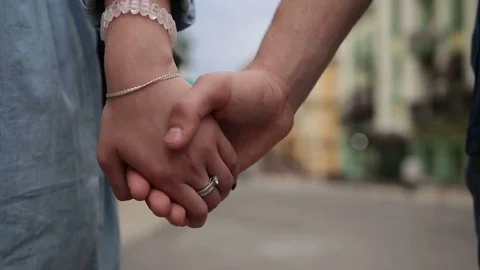 Close-up loving couple holding hands while walking Stock Footage