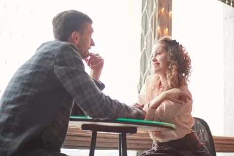 Close up. loving couple sitting at a table in a cozy cafe Stock Photos