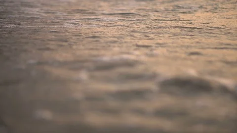 Close Up Low Angle of Calm Waves Crashing at Beach With Orange Sunset Colors Stock Footage 120331370