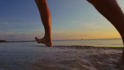Close Low Angle Dynamic View Of Male Feet Mid Step Above Wet Sand With Water Rip Stock Footage 331874817