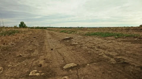 Close-up low-angle perspective of a dirt field road 1 Stock Footage 346702114