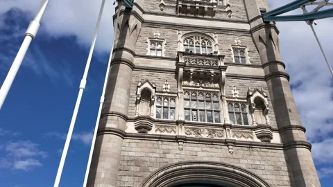 Close low-angle push under Tower Bridge stone tower with traffic light Stock Footage 346677599