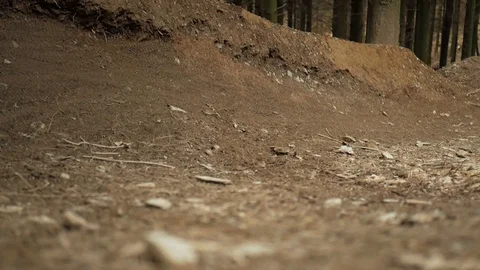 Close up, low angle shot of a mountain biker riding round a burm round to Stock Footage 108128406