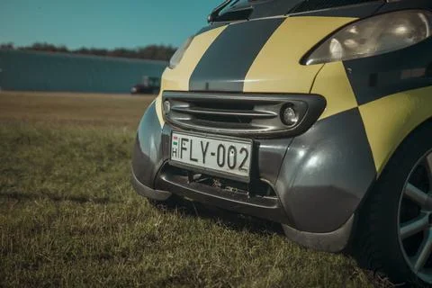 Close-up low angle shot of a small yellow and black car in a field Stock Photos