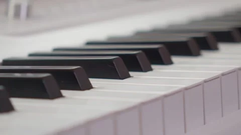 Close-up low angle slider shot of piano keys moving along the keys Video stock 338158748