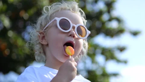 Close-up, low angle, slow motion, Caucasian blonde girl eating delicious sweet Stock Footage 243200134