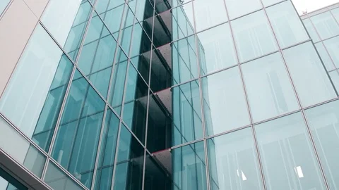 Close-up low angle steadicam shot of modern glass facade office building in Stock Footage 71321465