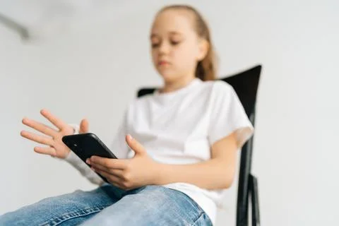 Close-up low-angle view of blonde little girl with broken arm wrapped in white Stock Photos