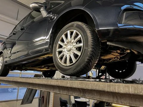 Close up low-angle view of car inspection on a service lift in a garage. Stock Photos