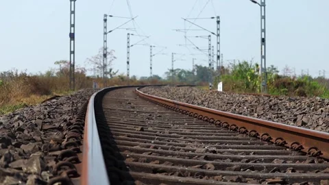 Close low angle view of curved railway track with electrified overhead lines Stock Footage 330705722
