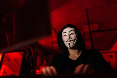 Close-up low-angle view of dangerous hacker man wearing anonymous mask and Stock Photos
