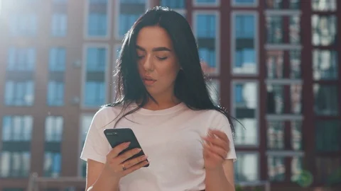 Close up low angle view of pretty long-haired brunette woman holding her Stock Footage 111218809