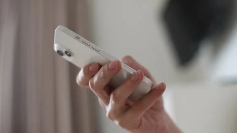 Close-up low-angle view of relaxed happy young man holding cellphone in hands Stock Footage 263734012