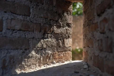 Close-up low-angle view through a narrow opening in a weathered brick wall, r Stock Photos