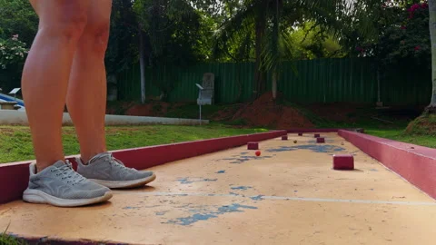 Close Up Low Angle View of Woman Hitting Mini Golf Ball With Putter on Obstacle Stock Footage 330889638