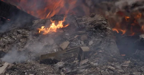 Close-up low flames burning in ash-covered rubble after a structure fire Stock Footage 59515253