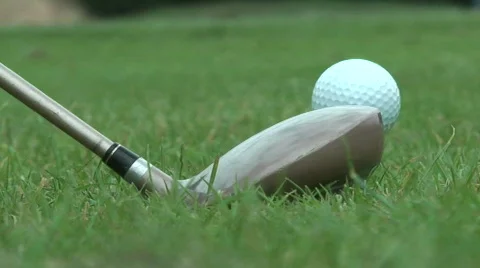 Close up low level shot of golf club hitting ball off a tee Stock Footage