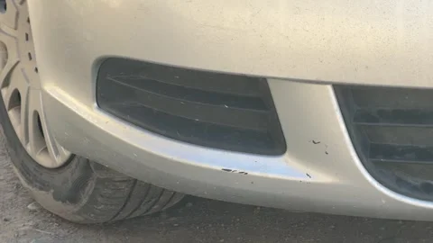 Close-up of the lower front bumper, air intake grille and tire on a silver car, Stock Footage 337113893