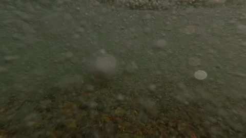Close-up from the lower level, Wave after wave runs onto the pebble shore Stock Footage 321934217