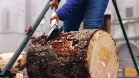 Close-up of a lumberjack removing bark from a pine log with an axe outdoors Video stock 304284852