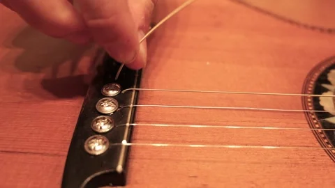 Close up of a luthier changing a guitar string Stock Footage 341376433