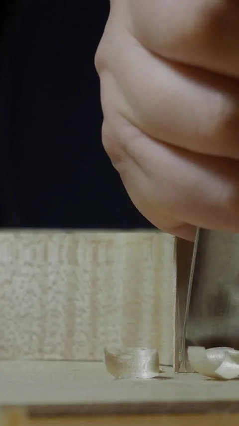 Close up of luthier's hands using bone scraper to smooth and shape wood corner Stock Footage 311694931