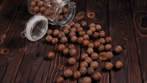 Close-up of macadamia nuts in a jar on a brown wooden background. Stock Footage 149732163