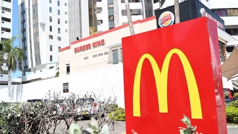 Close-up of a MacDonald sign, next to a fast food burger king Stock Footage 126824925