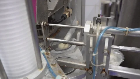 Close-up of a machine packs cheeses in a packages Stock Footage 129928137