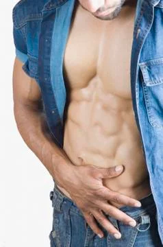 Close-up of a macho man checking his abdominal muscles Fotos Stock