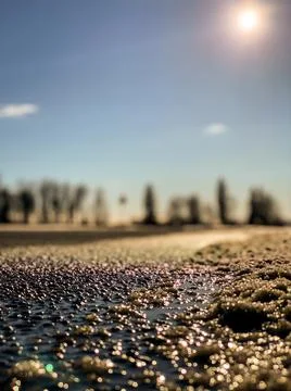 Close-up macro asphalt road texture in an orange summer evening sunset. Foto stock