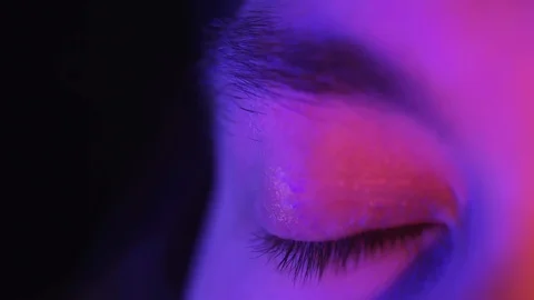 Close up macro blue eye opening beautiful iris natural human in neon light Stock Footage 130104341