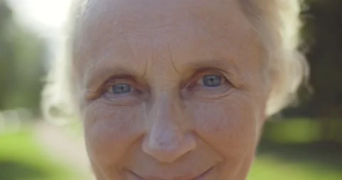 Close up macro bokeh shot of aged woman face looking at camera outdoors Stock Footage 158166530
