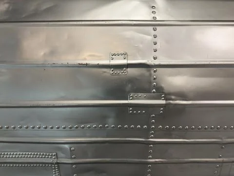 Close-up macro of bright silver colored metal wall with lines of rivets Stock Photos