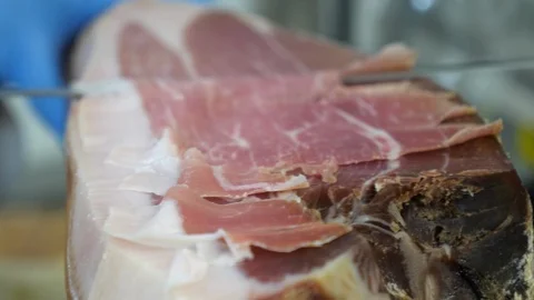 Close up macro of a chef who cuts a slice of ham Stock-Footage 91015583