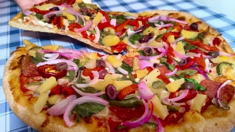 Close up macro dynamic view holding a slice of colorful vibrant pizza with .. Stockbeeldmateriaal 318267867