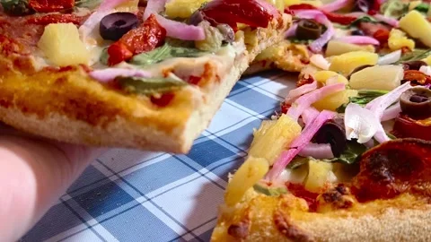 Close up macro dynamic view holding a slice of colorful vibrant pizza with .. Stockbeeldmateriaal 318267871