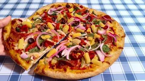 Close up macro dynamic view holding a slice of colorful vibrant pizza with .. Stockbeeldmateriaal 318267885