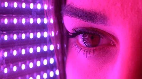 Close up macro eyes opening looking at intense blue, magenta light Video stock 112120526