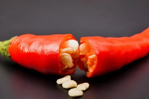 Close up of macro half broken red hot chilli peppers and chilli seeds Foto stock