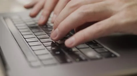 Close up macro of hands typing on laptop keyboard mac computer Stock Photos