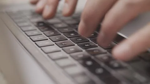 Close up macro of hands typing on laptop keyboard mac computer Stock Photos