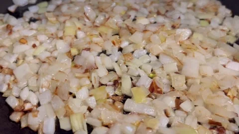 Close up macro horizontal video of frying chopped white onion in oil. Stock Footage 310960357