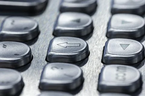 Close-up macro of metallic keypad arrow buttons on a brushed metal electron.. Stock Photos