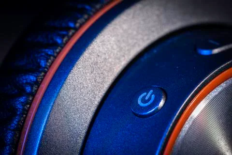 A close up macro photo of the power button on a pair of generic headphones wi Stock Photos